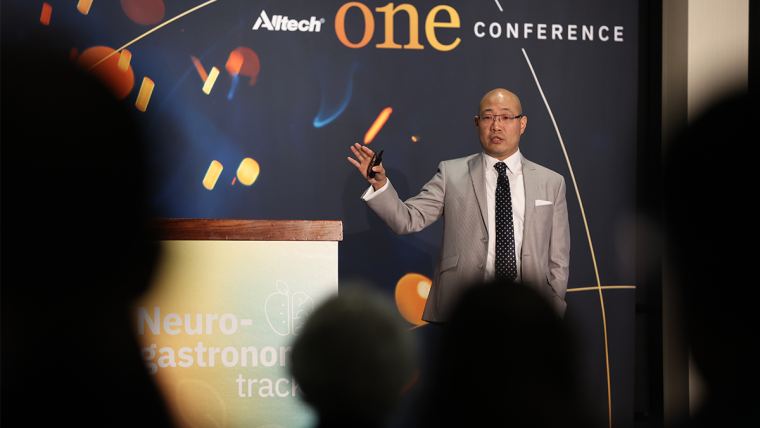 Dr. Dan Han on stage presenting in the Neurogastronomy track at the 2022 Alltech ONE Conference